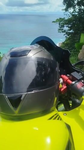 Yellow motorcycle parked at a scenic Phuket coastal overlook
