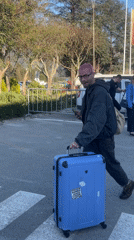 Pink-haired traveler with suitcase crosses street in Montenegro