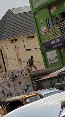 Man with box gestures from truck bed in Nigeria