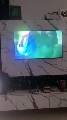 Music video plays on wall-mounted TV in Karmajiji