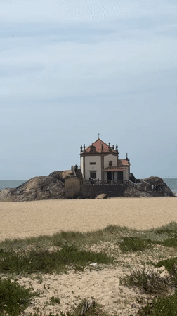 Visitor documents scenic chapel and coastline in Vila Nova de Gaia