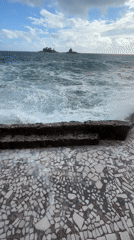Rough seas crash against stone wall in Petrovac, Montenegro