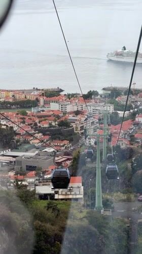 Cable car ride captured over Funchal's red roofs and coastline