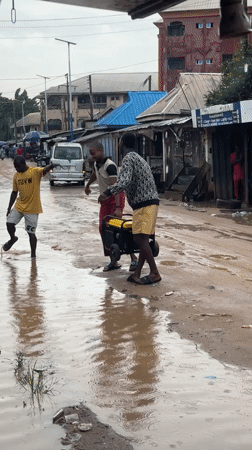 Flooding forces residents to wade through muddy streets in Nigeria