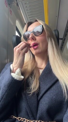 Woman applies lipstick during train journey in Latvia