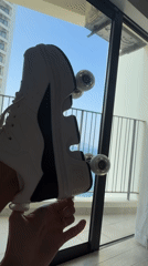 Person displays roller shoe by sunny window in Nha Trang