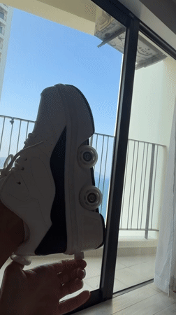 Person displays roller shoe by sunny window in Nha Trang