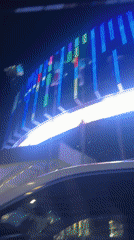 Nighttime drive through illuminated commercial district captured on video