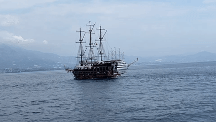 Pirate tour boats sailing past Alanya's clifftop fortress