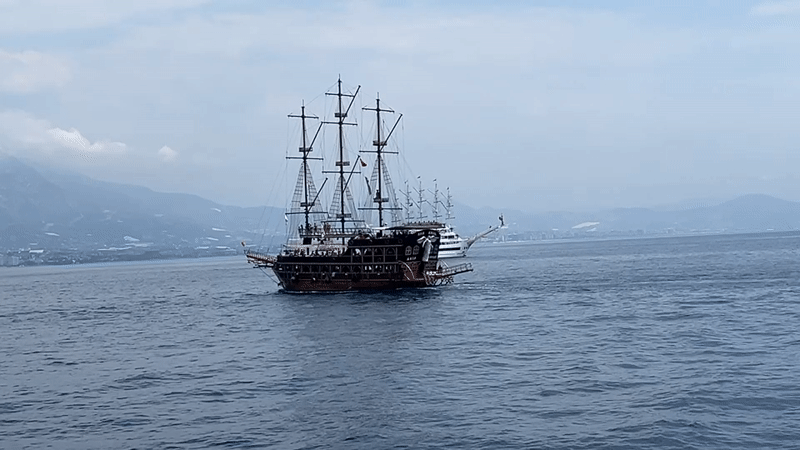 Pirate tour boats sailing past Alanya's clifftop fortress
