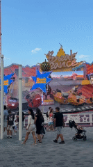 Afternoon at an outdoor amusement park, rides and crowds