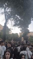 Young crowd gathers in park with music