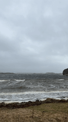 Person shields from weather at choppy Stensvik shoreline