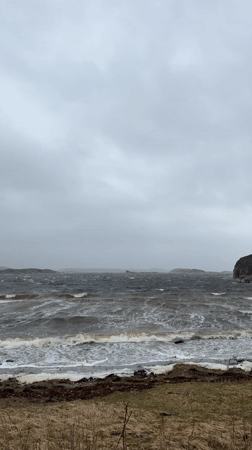 Person shields from weather at choppy Stensvik shoreline