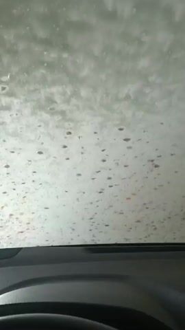 The video shows the view from inside a car going through a carwash. The windshield is covered in water and soap.