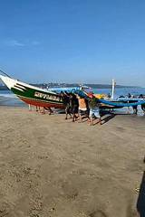 Fishermen move traditional boats on Kuta Selatan beach