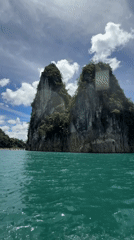 Narrow boat crossing turquoise waters off Khao Phang, Thailand