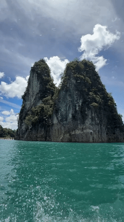 Narrow boat crossing turquoise waters off Khao Phang, Thailand