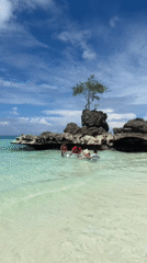 Sunny morning on Boracay's shoreline, rocks, shrines, and selfies