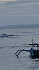 Community beach cleanup documented in Denpasar at dusk