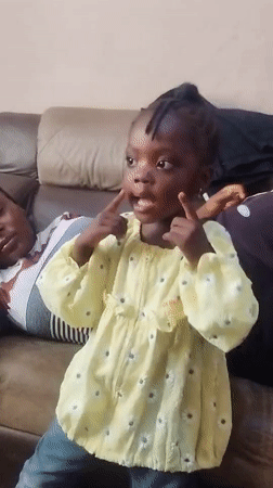 Family relaxes together on couch in Jos home