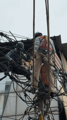 Electrical work on a tangled pole near Mehrauli's historic streets