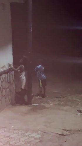 Group gathering near building in Akwanga, one person runs