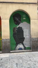 Street art murals documented on Barcelona storefront shutters