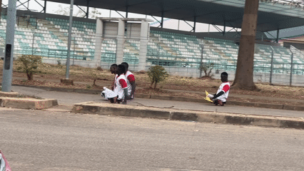 Four people in sports attire gather near stadium