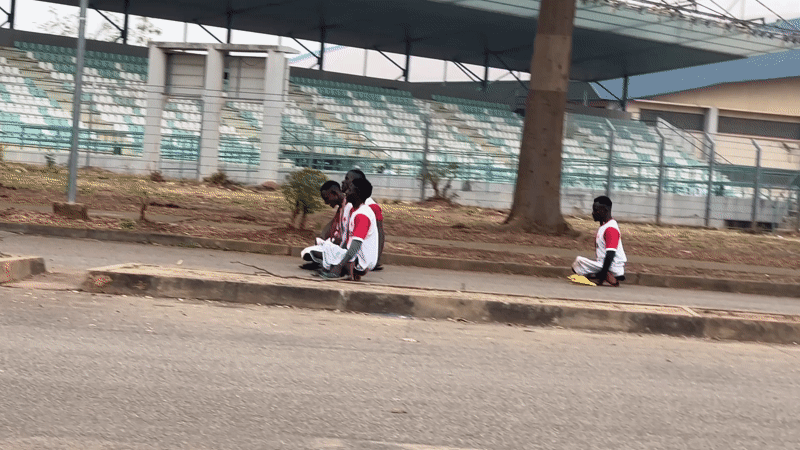 Four people in sports attire gather near stadium