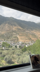 Train passenger captures rural Chinese village beneath terraced mountains