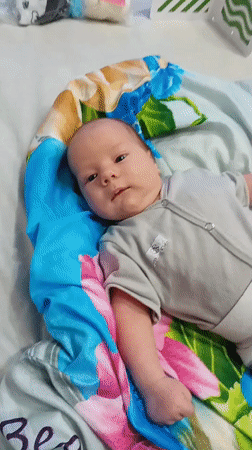 Baby plays with rattle on blanket in Andreyevo