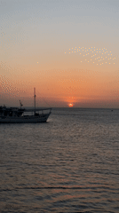 Man takes selfies at Juan Griego harbor during sunset