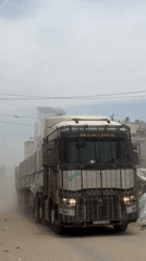 Commercial truck navigates dusty Gaza street conditions