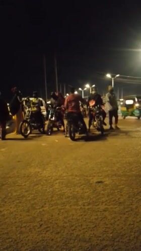 Evening street market bustles with vendors, motorcycles in Bukuru