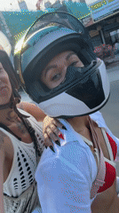 Two women ride motorbike through Vietnamese ward street