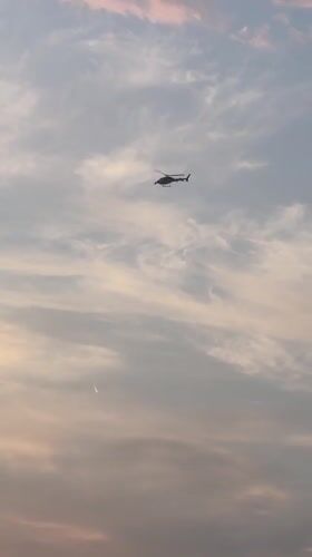 Paris rooftops at dawn on Bastille Day, helicopters overhead