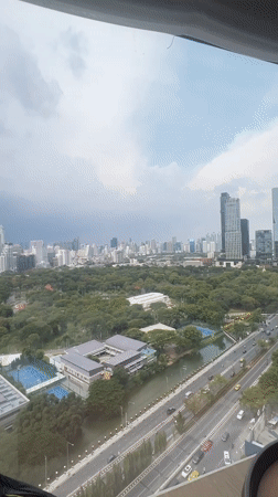Bangkok skyline viewed from high-rise window overlooking city park