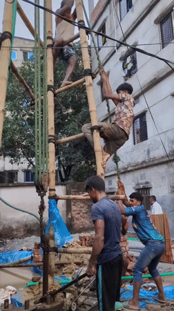 Bamboo scaffolding and drilling work at a Dhaka construction site