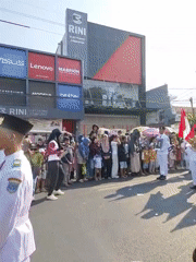 Uniformed parade marches through Probolinggo streets with flags and band