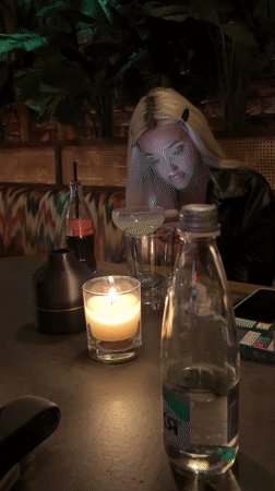 Woman checks phone at table with drink in Plovdiv