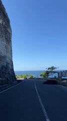 Coastal road filmed descending toward ocean in Kuta Selatan