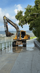Excavator works near tranquil waterway in Ban Bang Rak