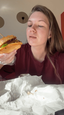 Woman enjoys burger lunch at KP Burger in Belgrade