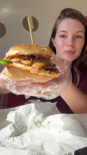 Woman enjoys burger lunch at KP Burger in Belgrade