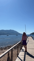 Woman enjoys sunny morning on Budva pier overlooking water