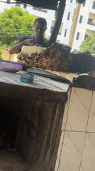 Food vendor prepares cheese-topped meat dish in Nigerian town