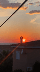 Woman documents sunset moment in coastal Montenegro village
