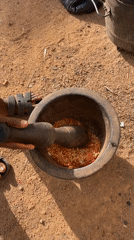Person grinds ingredients with mortar and pestle in Nigeria
