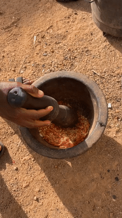 Person grinds ingredients with mortar and pestle in Nigeria